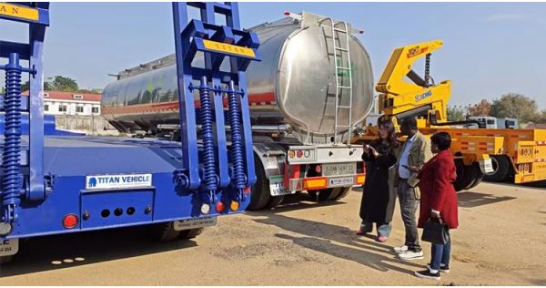 Clientes de Guyana visitan la fábrica de TITAN para ver los remolques de plataforma baja en stock.
