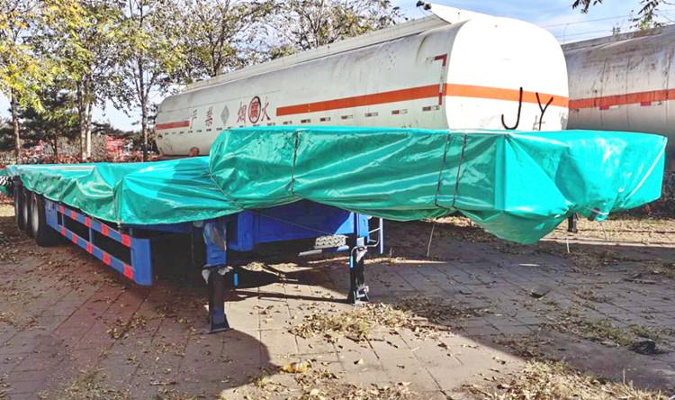 Un cliente camerunés inspecciona el remolque de plataforma baja antes de la entrega