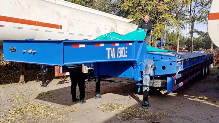 Un cliente camerunés inspecciona el remolque de plataforma baja antes de la entrega