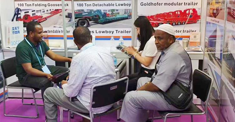 Clientes nigerianos visitan el stand de TITAN en la Feria de Cant&oacute;n para comprar un remolque de cuello de cisne plegable.