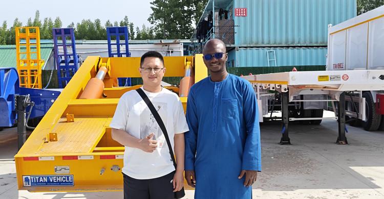 Clientes nigerianos visitan TITAN para comprar un remolque de plataforma baja con cargador frontal.